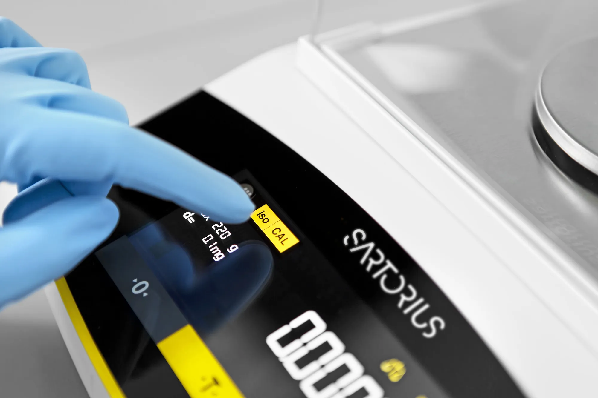 Auch mit Handschuhen gut bedienbar: Über das Touchdisplay starten Sie mit isoCAL die interne Justierung der Waage. Die Abbildung zeigt die Essential-Ausführung mit Glaswindschutz und vier Nachkommastellen. Das von Ihnen ausgewählte Modell zeigt Wägeergebnisse mit einer Nachkommastelle.